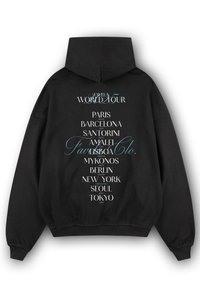 Black sweatshirt with a hood, featuring white and light blue text listing cities from a world tour, centered on the back.