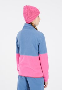 Fleece pullover met een blauwe bovenkant en een roze onderkant. Heeft een hoge kraag en een gestikte roze gebreide muts.