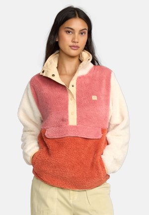 Fleece pullover in het roze, wit en oranje met een hoge kraag, drukknoopjes en een voorzak. Zachte textuur met een gezellige uitstraling.
