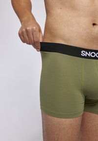 Olivgrüne Baumwoll-Boxershorts mit einem schwarzen elastischen Bund, der den Markennamen "SNOOD" in Weiß trägt, im enganliegenden Design.