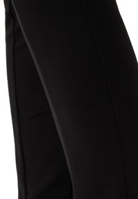 Leggings neri realizzati in tessuto elasticizzato, caratterizzati da una texture liscia e un design aderente con cuciture laterali a contrasto.