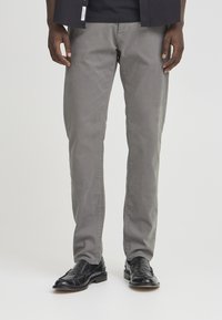Gray chinos made of cotton, featuring a straight leg design. Paired with black leather loafers. Simple and classic cut.
