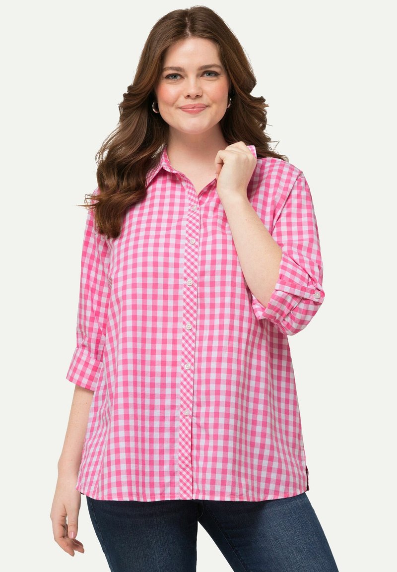 Camicia a quadri rosa con maniche lunghe arrotolate, dotata di colletto classico e orlo con spacco laterale. Materiale in cotone testurizzato.
