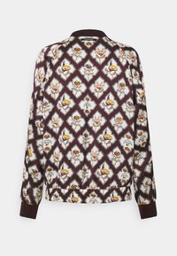 Veste bomber marron avec des motifs floraux et géométriques en blanc, jaune et rose, avec poignets et bas en bord-côte.
