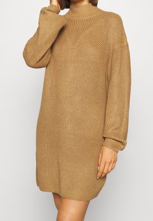 Abito maglione a maniche lunghe in marrone chiaro con collo alto e vestibilità ampia; presenta un tessuto testurizzato e polsini a costine.