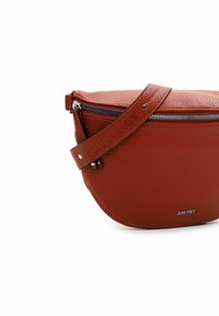 Red leather crossbody bag with a rounded shape, textured surface, zip closure, and a strap featuring embossed branding.