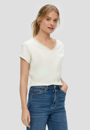 White V-neck t-shirt with short sleeves, made of soft fabric. Features delicate stitching along the neckline. Worn with high-waisted denim jeans.