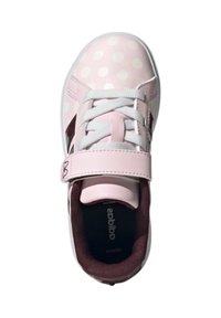 Chaussure pour enfant rose clair avec des pois blancs, dotée d'une sangle en velcro, de lacets blancs et d'une doublure intérieure bordeaux.