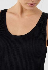 Zwarte geribde tanktop met een ronde halslijn. Kenmerkt zich door een gestructureerde stof en een getailleerd ontwerp, met subtiele verticale groeven.
