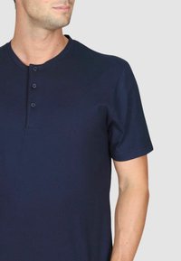 Polo a maniche corte blu navy con collo henley e tre bottoni, realizzato in tessuto morbido con un design aderente.