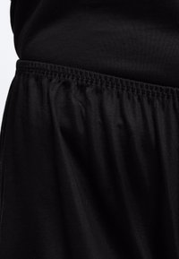 Κοντινό πλάνο μαύρης ελαστικής ζώνης στησαρμένης υφής, εμφανίζοντας λεπτομέρειες υφής και ραφών.