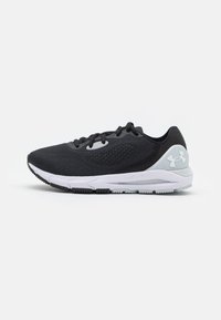 Chaussure de sport noire avec une tige en maille textur�ée, semelle blanche rembourrée et accents gris clair. Dispose d'un système de laçage traditionnel.