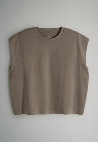 Ruskea lyhyt hihaton paita pyöreällä kaula-aukolla, pehmeästä kankaasta valmistettu. Sileä pinta, vähäiset sauman yksityiskohdat ja rento istuvuus.