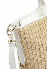 Vævet beige håndtaske med struktureret overflade, hvide læderdetaljer, en guldlås og dobbelte håndtag for nem bæring.