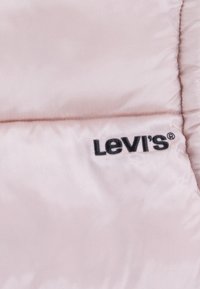 Padded pink quilted jacket featuring a smooth texture and black embroidered Levi's logo on the left side.