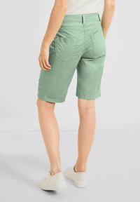 Shorts cargo vert clair à coupe décontractée, dotés de deux poches arrière et d'un ourlet retroussé. Fabriqués à partir d'un tissu lisse et respirant.