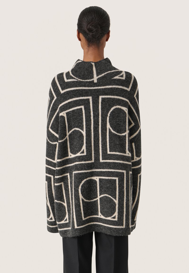 Übergroßer Wollpullover in Dunkelgrau mit cremefarbener geometrischer Musterung, mit hohem Kragen und nahtloser Verarbeitung. Lockere Passform, lange Ärmel.