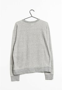 Felpa grigia con una vestibilità rilassata, scollo e polsini a costine. Il tessuto sembra morbido con una texture liscia, appesa a un gancio nero su uno sfondo bianco.