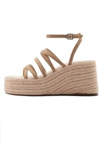 Kilklacksandal med en texturerad ljusbeige espadrille-plattform, med flera smala remmar och ett justerbart ankelspenne.