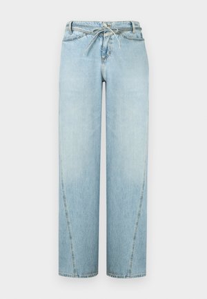 Πλεκτή ζακέτα με μπλε και κρεμ ρίγες, κοντά φουσκωτά μανίκια και κουμπιά μπροστά. Συνδυασμένη με ανοιχτό μπλε τζιν παντελόνι φαρδιάς γραμμής και παπούτσια με animal print.