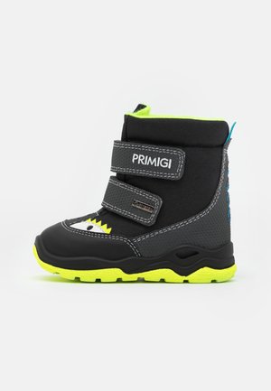 Botte noire imperméable avec deux sangles Velcro, accents et semelle jaune fluo, talon gris caoutchouté, et design ludique d'œil et de dents.