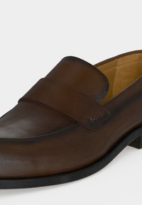 Καφέ δερμάτινα ανδρικά loafers με μαύρη σόλα, σχεδιασμός slip-on και το λογότυπο BOSS ανάγλυφο στο λουρί.
