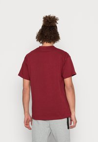 Maroon cotton t-shirt with short sleeves and a crew neck. Simple design with no visible patterns or accents. Back view displayed.