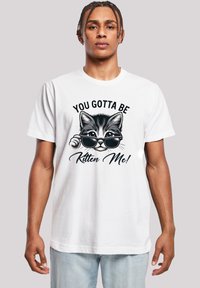 Weißes Baumwoll-T-Shirt mit einem Grafikmotiv eines Katers, der Sonnenbrillen trägt, und dem Text "DU MUSST MICH VERRÜCKT MACHEN!" in schwarzer Schrift.