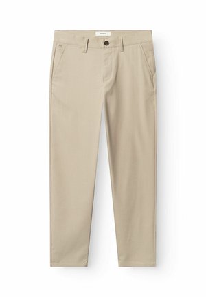 Beežid sirge lõikega püksid rihmalõngadega, ees lukustus nupu ja tõmblukuga, küljetaskutega, asetatud valgele taustale.