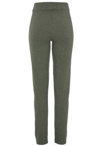 Pletene tajice u maslinastoj boji, s užim dizajnom i širokim elastičnim pojasom. Glatka tekstura bez vidljivih uzoraka ili akcenata.