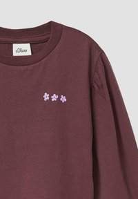 Bordeauxrotes Langarm-T-Shirt mit Rundhalsausschnitt, das drei helllila Blumenstickereien im Brustbereich zeigt. Aus weichem Baumwollmaterial.