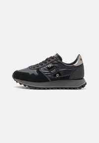 Zwarte sneaker met een mix van suède en glanzende synthetische materialen. Beschikt over gestructureerde oppervlakken, opvallende stiksels en een rubberen zool met grip.