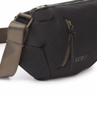 Zwarte schoudertas gemaakt van gladde stof, voorzien van een ritssluiting en een duurzame, verstelbare beige riem. Subtiel KCB-logo detail.