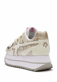 Witte en beige sneaker met metallic gouden accenten, textuur mesh bovenwerk, gestreept ontwerp, dikke witte zool met grijze details en gehakkende rand.