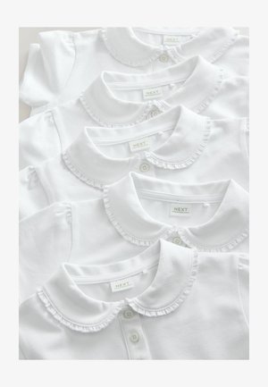 Četiri bijele košulje s ovratnicima, s naboranim rubovima, uredno složene, s dugmadima i oznakama vidljivim na ovratnicima.