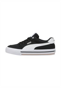 Sneaker bianco e nero con tomaia in tela testurizzata, design con lacci, collo imbottito e suola in gomma con accenti a strisce.