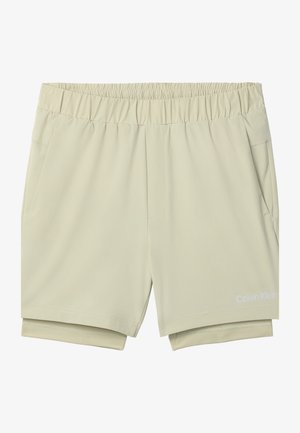 Beżowe szorty z elastycznym pasem, wewnętrzną warstwą kompresyjną, bocznymi kieszeniami i logo Calvin Klein na dolnej części prawej nogawki.
