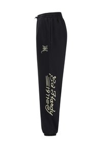 Svarta sweatpants med elastisk midja, muddar vid anklarna och framträdande vita textdesigns längs benet. Mjukt tyg med slät yta.