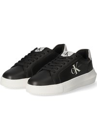 Sneaker in pelle nera con suola in gomma bianca, caratterizzate da un logo sul lato, punta rotonda e design con lacci standard.