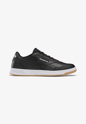 Baskets Reebok basses noires avec semelle intermédiaire blanche et semelle extérieure en gomme, fermeture à lacets et logo Reebok sur le côté et le talon.