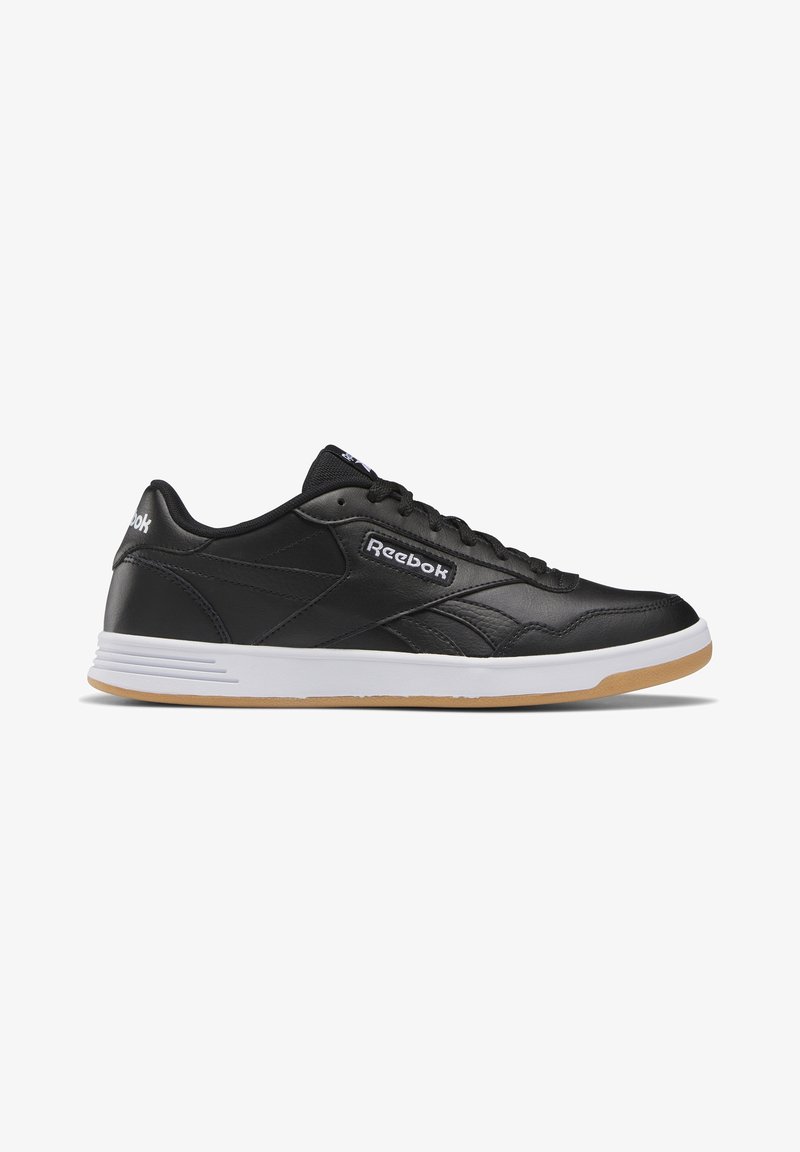 Baskets Reebok basses noires avec semelle intermédiaire blanche et semelle extérieure en gomme, fermeture à lacets et logo Reebok sur le côté et le talon.