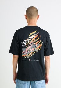 Black short-sleeve t-shirt featuring a colorful graphic of a racing car and checkered flags on the back.