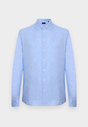 Chemise homme manches longues bleu clair avec boutonnière sur le devant et col classique sur un fond gris clair uni.