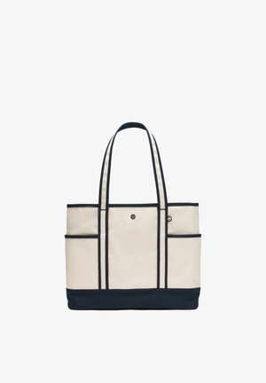 Beige Canvas-Tragetasche mit schwarzem Rand, schwarzem Boden, zwei hohen Griffen und kleinem Logo in der vorderen Mitte.