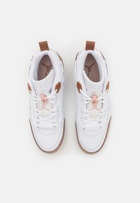 Vita sneakers med en slät yta, bruna detaljer, nätpaneler och en strukturerad sula. Har snören och en liten rosa detalj på tungan.