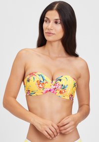 Strapless gele bikini top met bloemmotief in roze, oranje en groen; gladde textuur; gebogen vorm accentueert de buste.