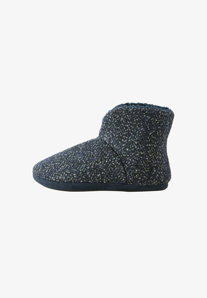 Chausson en laine bleu foncé avec une finition texturée, design mi-haut, doublure douce et semelle en caoutchouc flexible pour le confort.