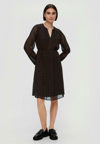 Zwart en bruin geruit jurk met lange mouwen, V-halslijn en een getailleerde taille, met een licht transparante textuur. Elegante jurk van knielange lengte.