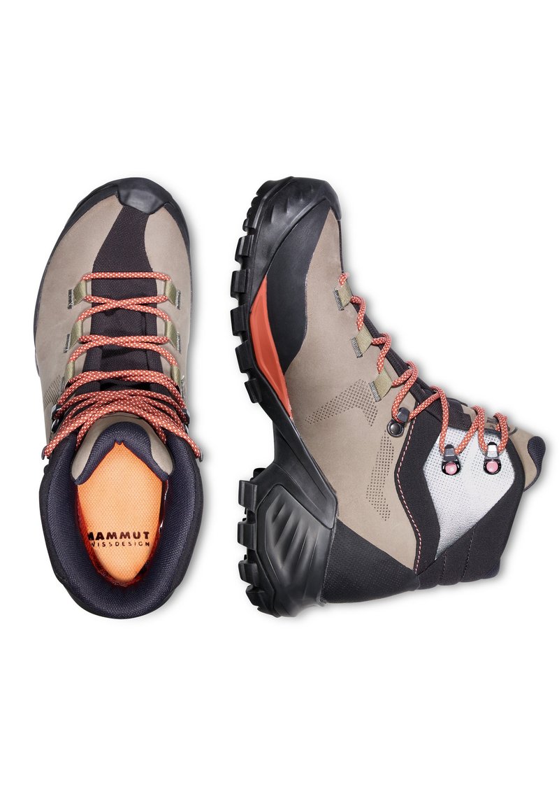 Buty trekkingowe z beżową zamszową cholewką, czarnymi akcentami, pomarańczowymi sznurówkami i teksturowaną gumową podeszwą zaprojektowaną z myślą o przyczepności i trwałości.