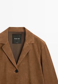Bruine suède blazer met één knoop, notched revers en zichtbaar Massimo Dutti label aan de binnenkant van de kraag.